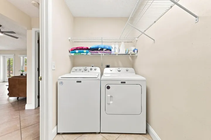 Dedicated laundry area featuring a white top-load washing machine and front-load dryer