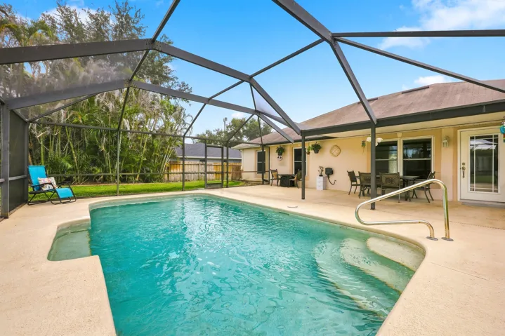 Screened swimming pool with integrated steps and a spacious concrete deck