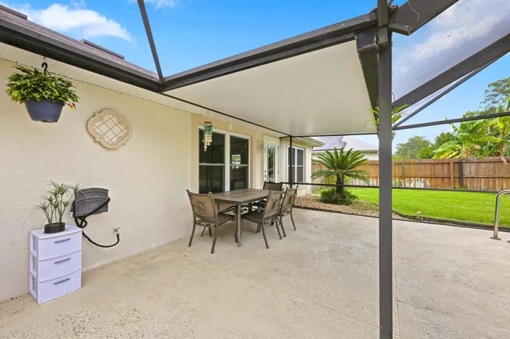 Screened lanai with a concrete patio, a covered dining area, and a privacy​​‌​​​​‌​​‌‌​‌‌​​​‌‌​‌​‌​‌​​​‌​​ fence