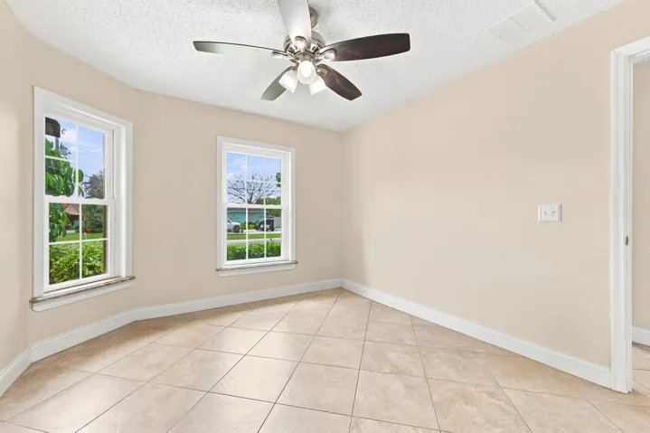 Room featuring neutral-toned tile flooring, light-colored walls, and white baseboards