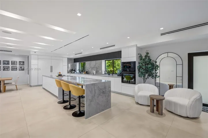 A chef-inspired kitchen designed for effortless entertaining, featuring premium finishes, an oversized waterfall island, and seamless integration with the home’s open living spaces.