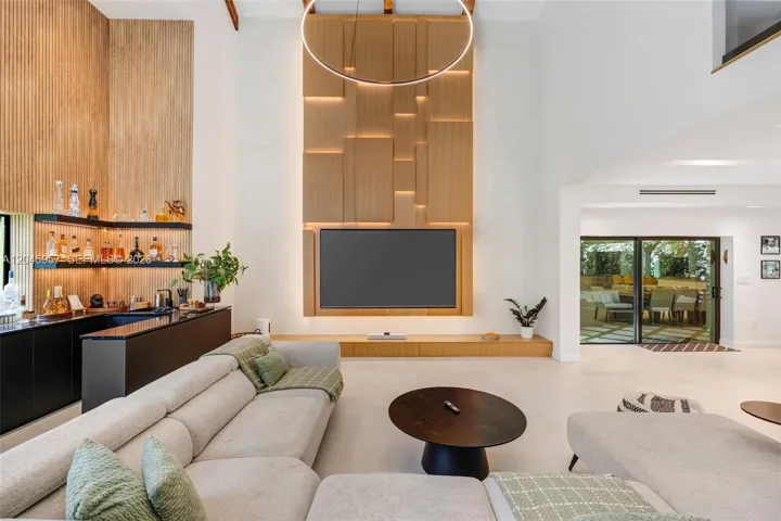 The heart of the home—soaring two-story ceilings, dramatic architectural volume, and a custom feature wall creates an unforgettable first impression