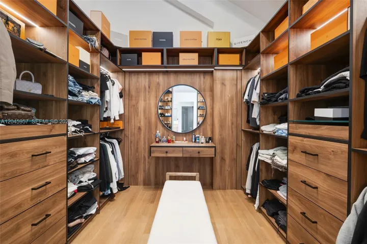 A boutique-inspired custom wardrobe with extensive built-ins, integrated lighting, and abundant storage designed for everyday luxury.