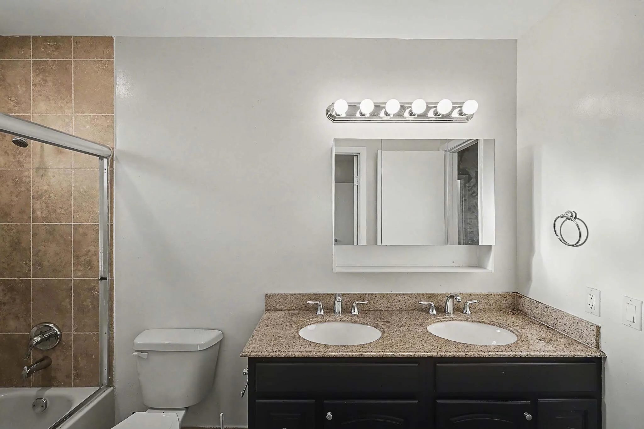 Double vanity featuring integrated sinks and a speckled countertop