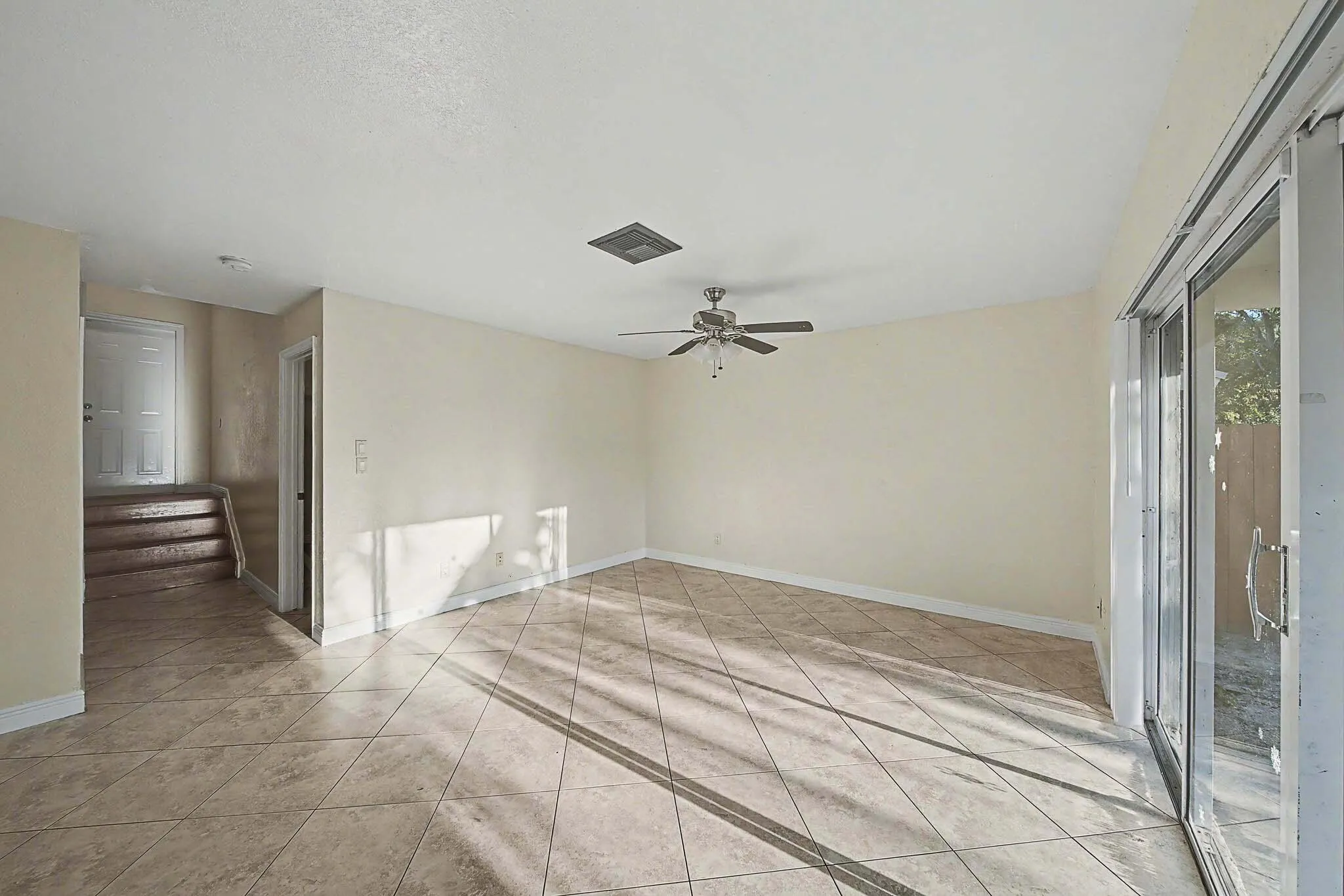 Spacious interior featuring neutral-toned walls and diamond-set tile flooring