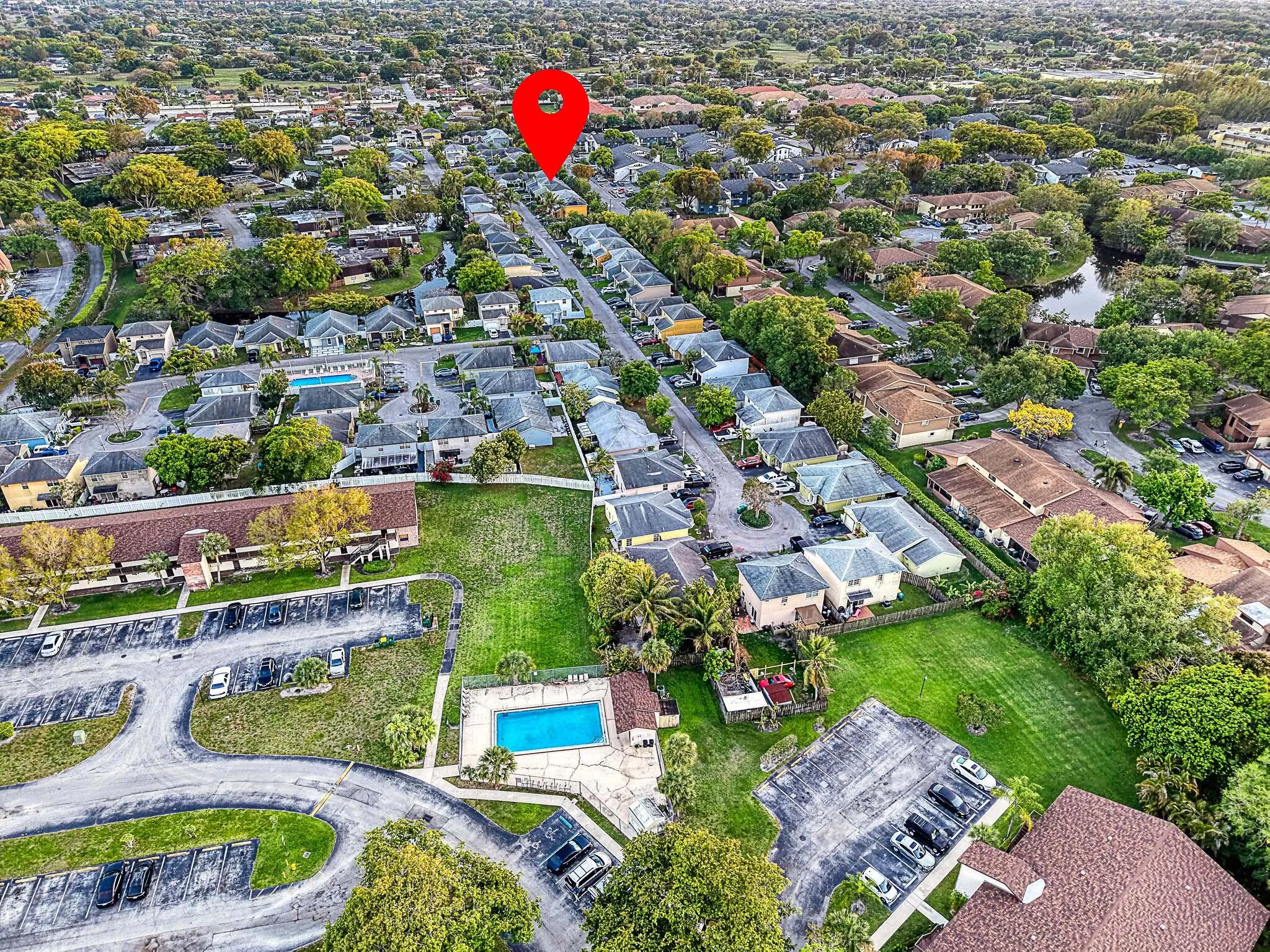 Aerial perspective showcasing a residential community with abundant green spaces and mature trees