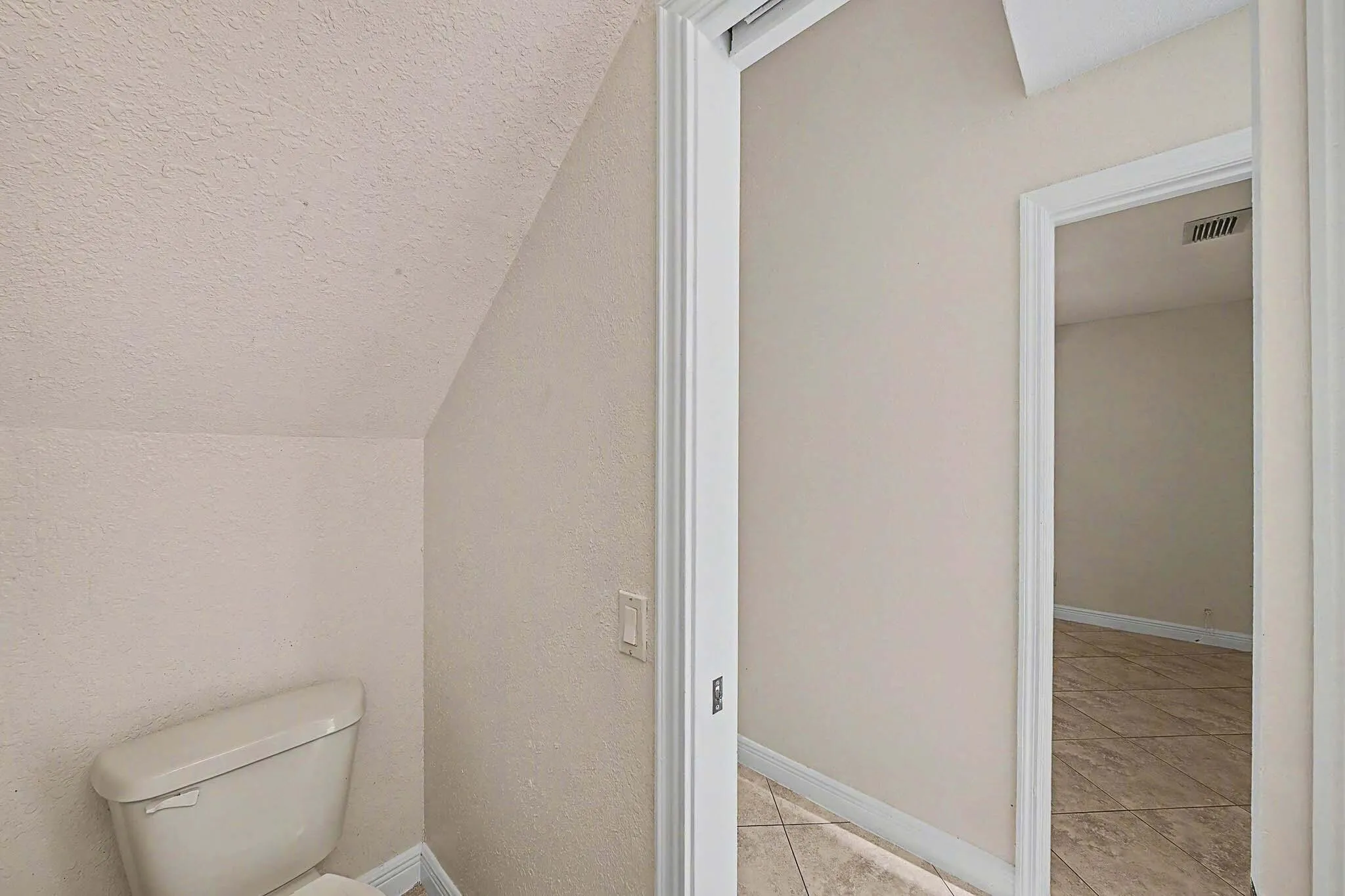 Compact powder room with a white toilet and textured walls