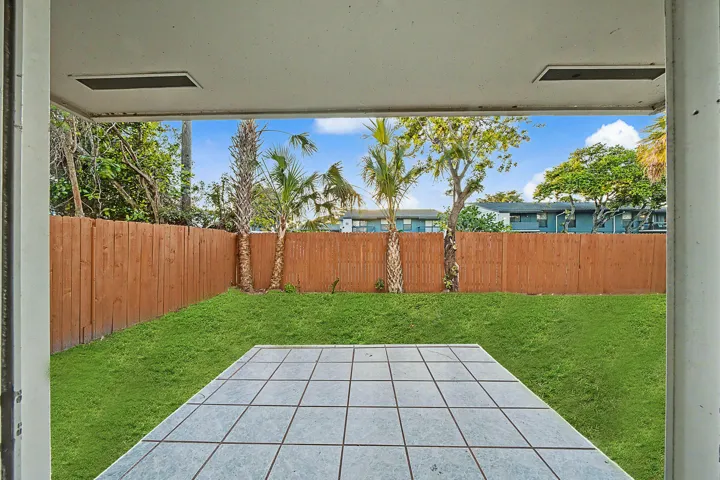 Private outdoor space featuring a rectangular patio with light-toned square tiles