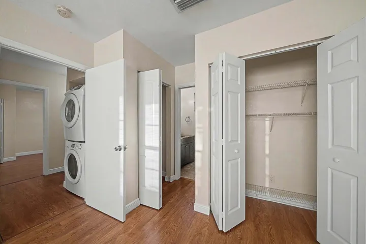 Integrated laundry area featuring a stacked washer and dryer