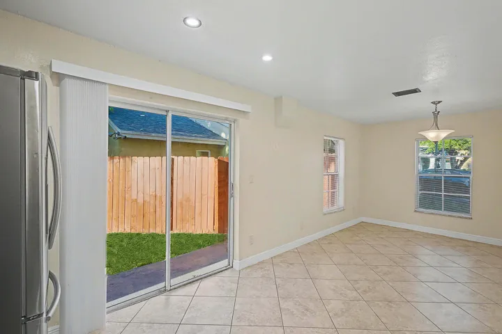 Bright interior space featuring large sliding glass doors opening to a private backyard