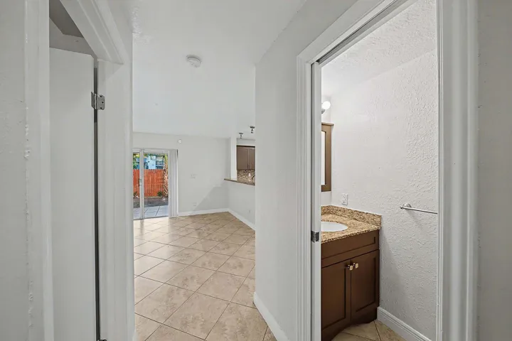 Interior hallway featuring tile flooring and white walls