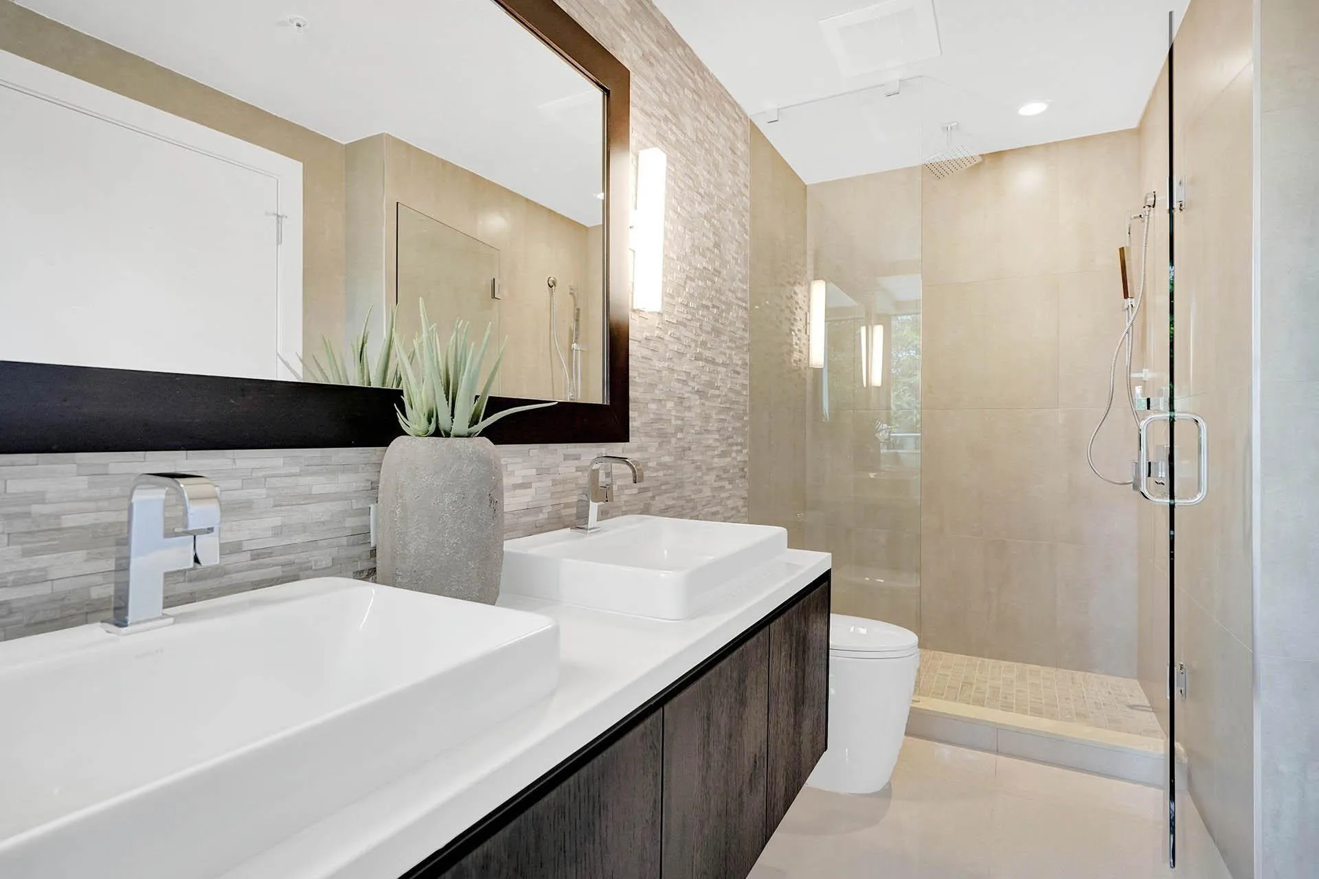 Bathroom featuring a dual vanity with rectangular vessel sinks, dark wood-finish cabinetry, and a full-width mirror
