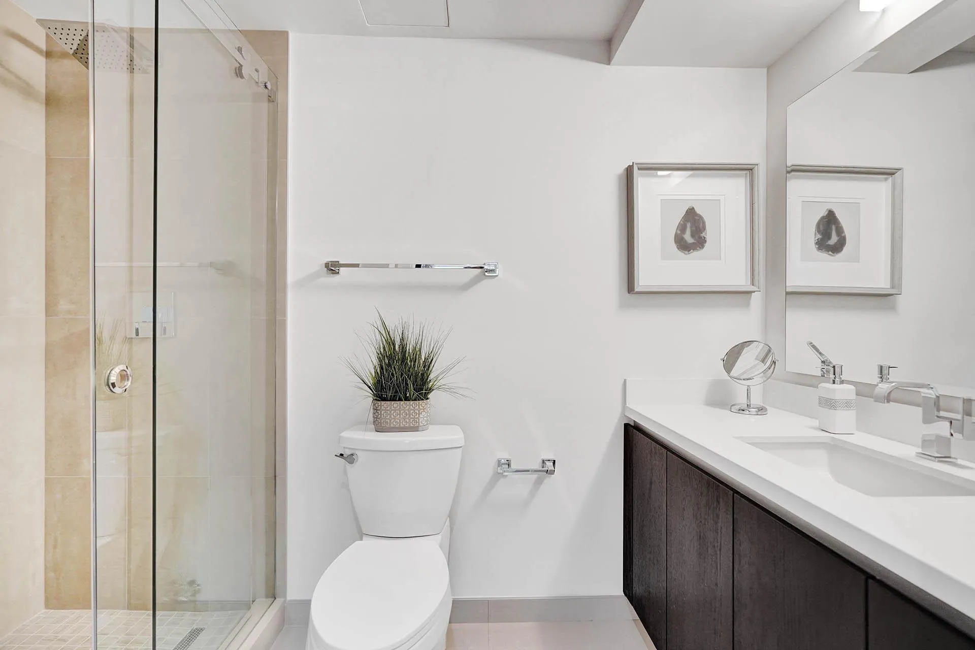 Contemporary bathroom featuring a floating double-sink vanity with white quartz countertop and brushed nickel fixtures, paired with dark wood cabinetry