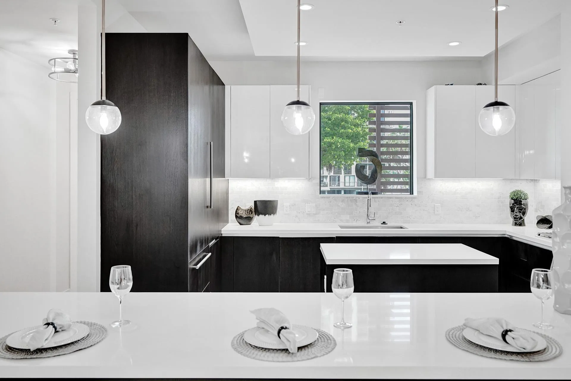 Modern kitchen featuring white countertops, two-tone cabinetry, and a white tile backsplash
