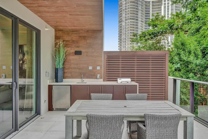 Outdoor kitchen featuring a built-in sink, under-counter refrigerator, and ample cabinetry