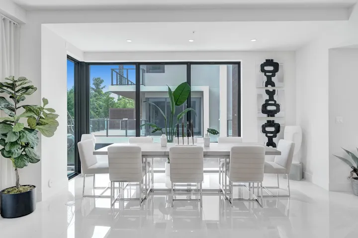 Open-concept dining space with high ceilings and polished tile flooring