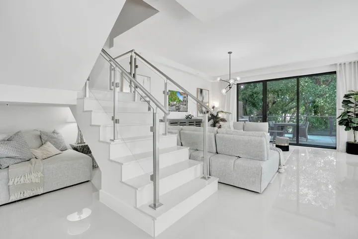 Contemporary interior featuring a prominent staircase with glass and stainless steel railing