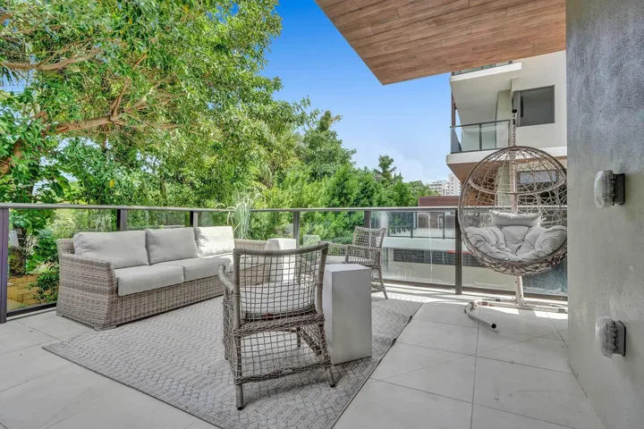Spacious outdoor balcony featuring tile flooring and glass railings