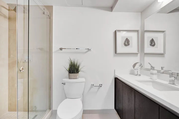 Contemporary bathroom featuring a floating double-sink vanity with white quartz countertop and brushed nickel fixtures, paired with dark wood cabinetry