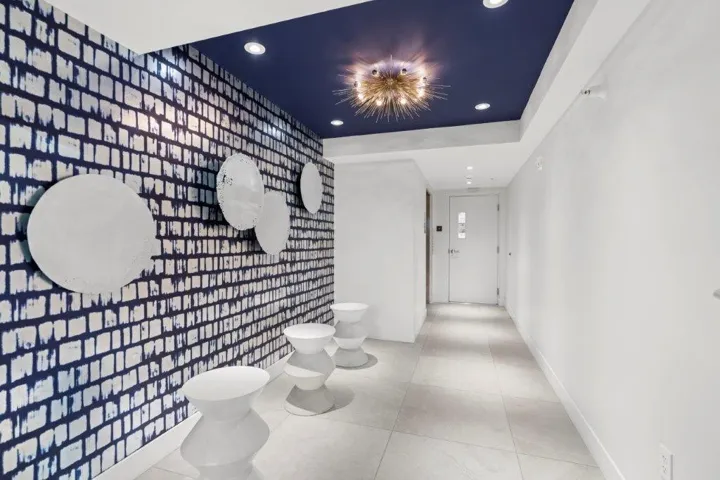 Entryway featuring a patterned accent wall, recessed lighting, and a dark blue ceiling