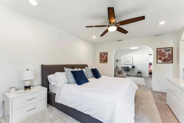 Spacious sleeping area featuring wood-finish flooring, recessed lighting, and a ceiling fan with integrated lighting