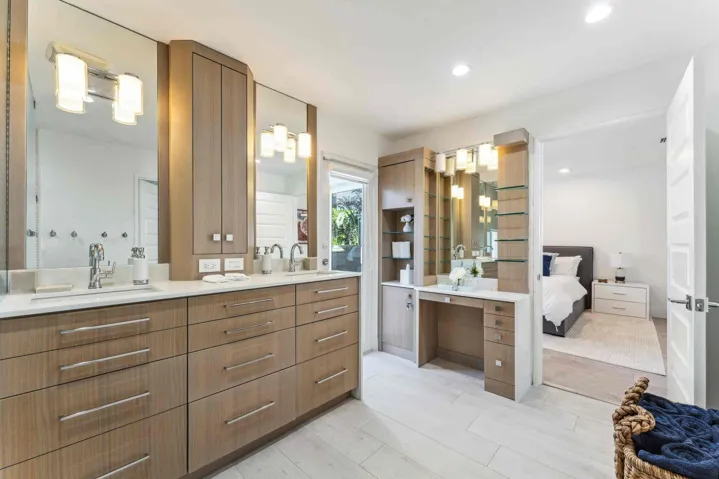 Spa-inspired primary bathroom suite featuring dual wood-finish vanities with white quartz countertops, integrated vessel sinks, and chrome fixtures