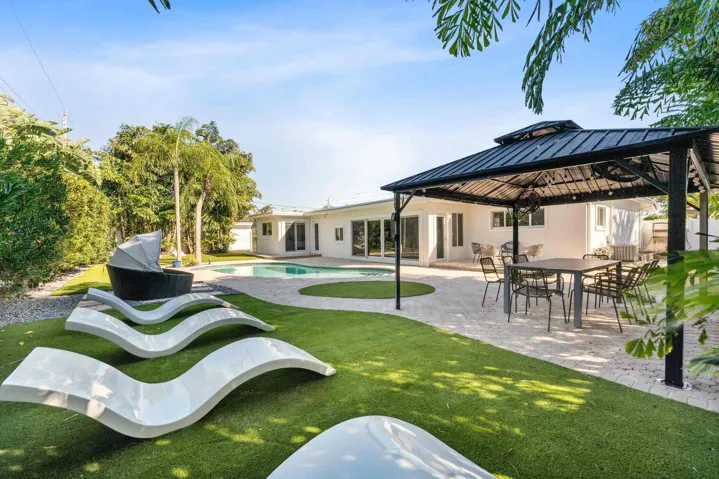 Expansive backyard featuring a lush green lawn and mature trees