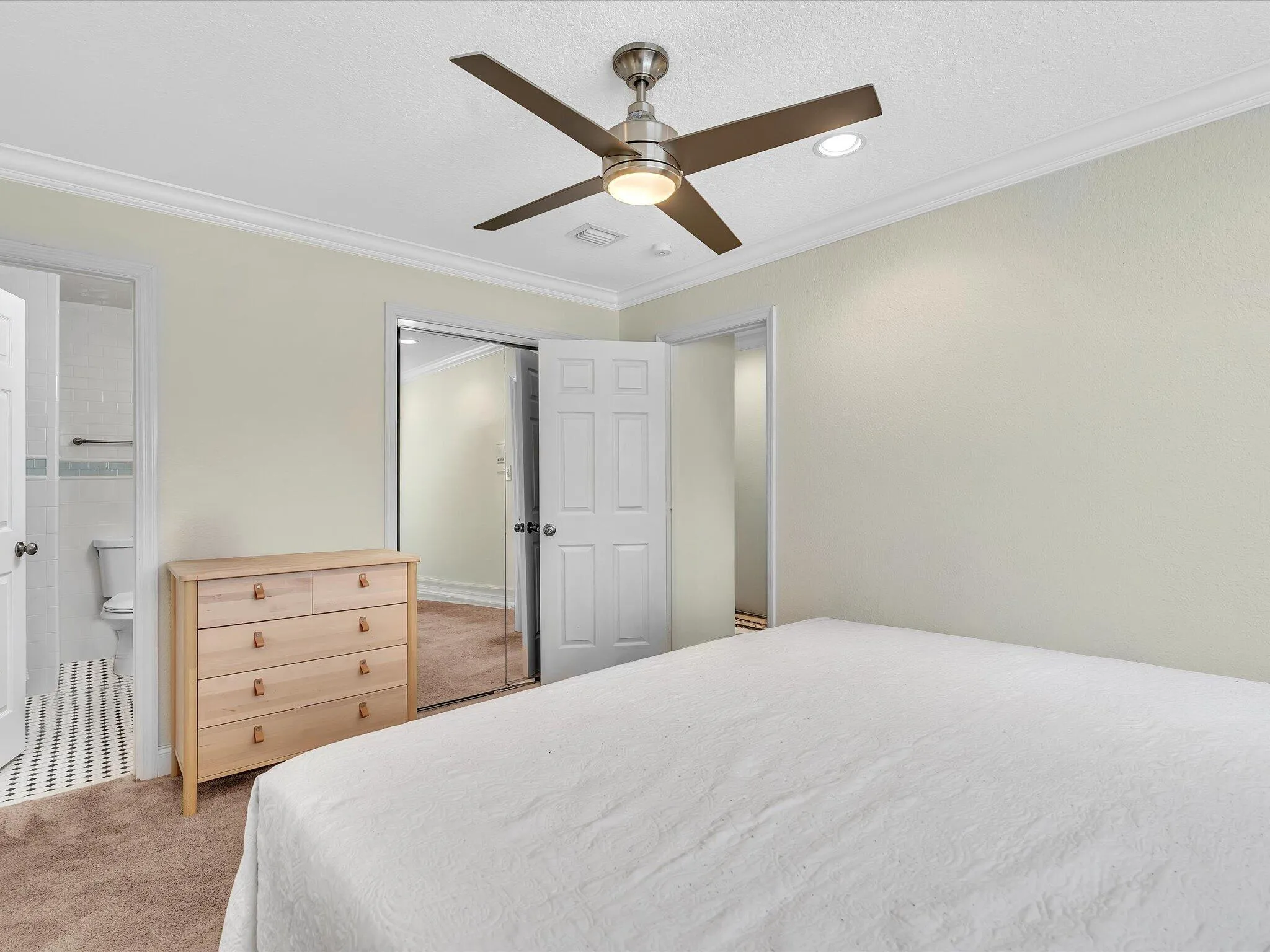 Crown molding, recessed lighting, ceiling fan with light fixture, mirrored closet doors, and carpeted flooring