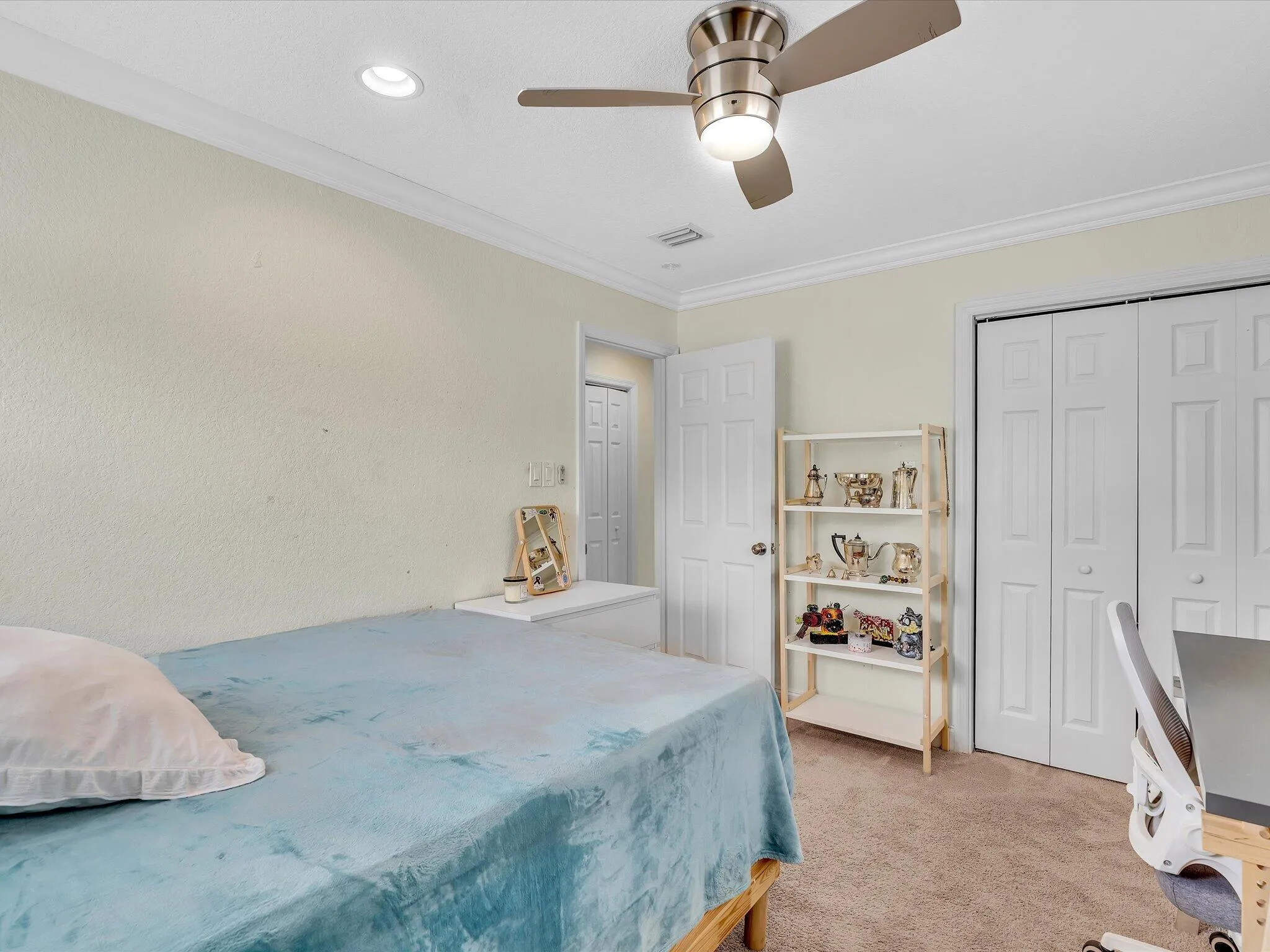 Spacious secondary bedroom featuring neutral wall finishes, wood-finish flooring, and abundant natural light from recessed ceiling fixtures