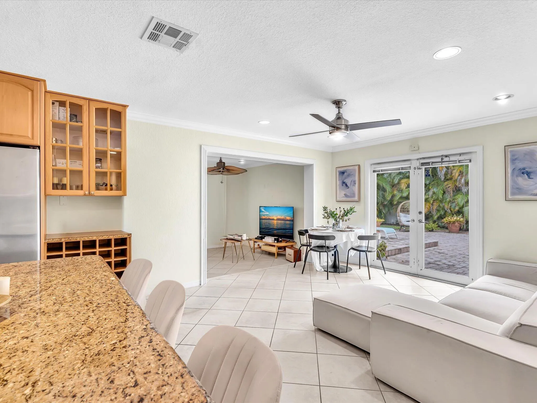 Open-concept living space with tile flooring, recessed lighting, and a ceiling fan