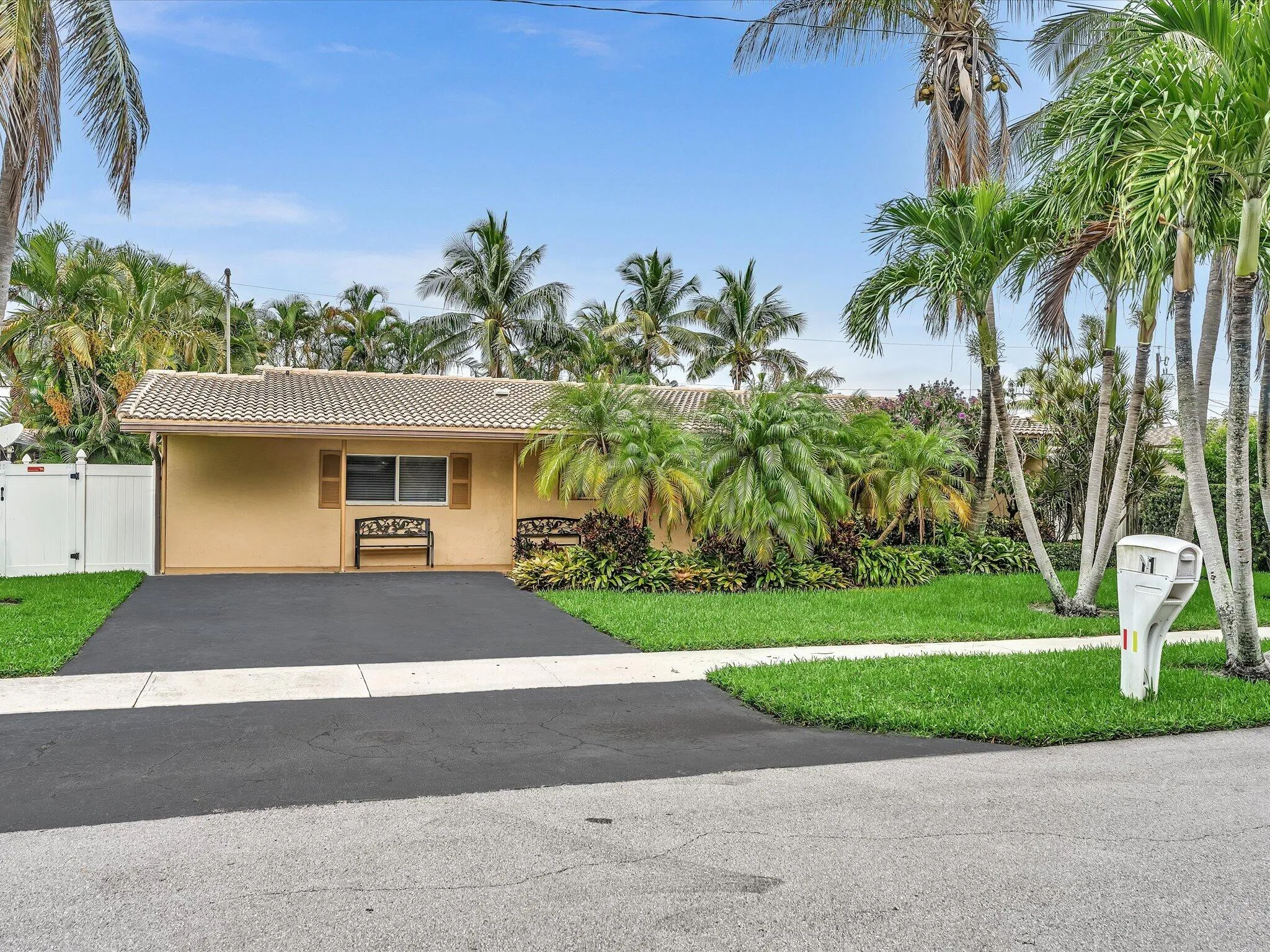 Single-story residence with a tiled roof, stucco exterior, and a paved driveway