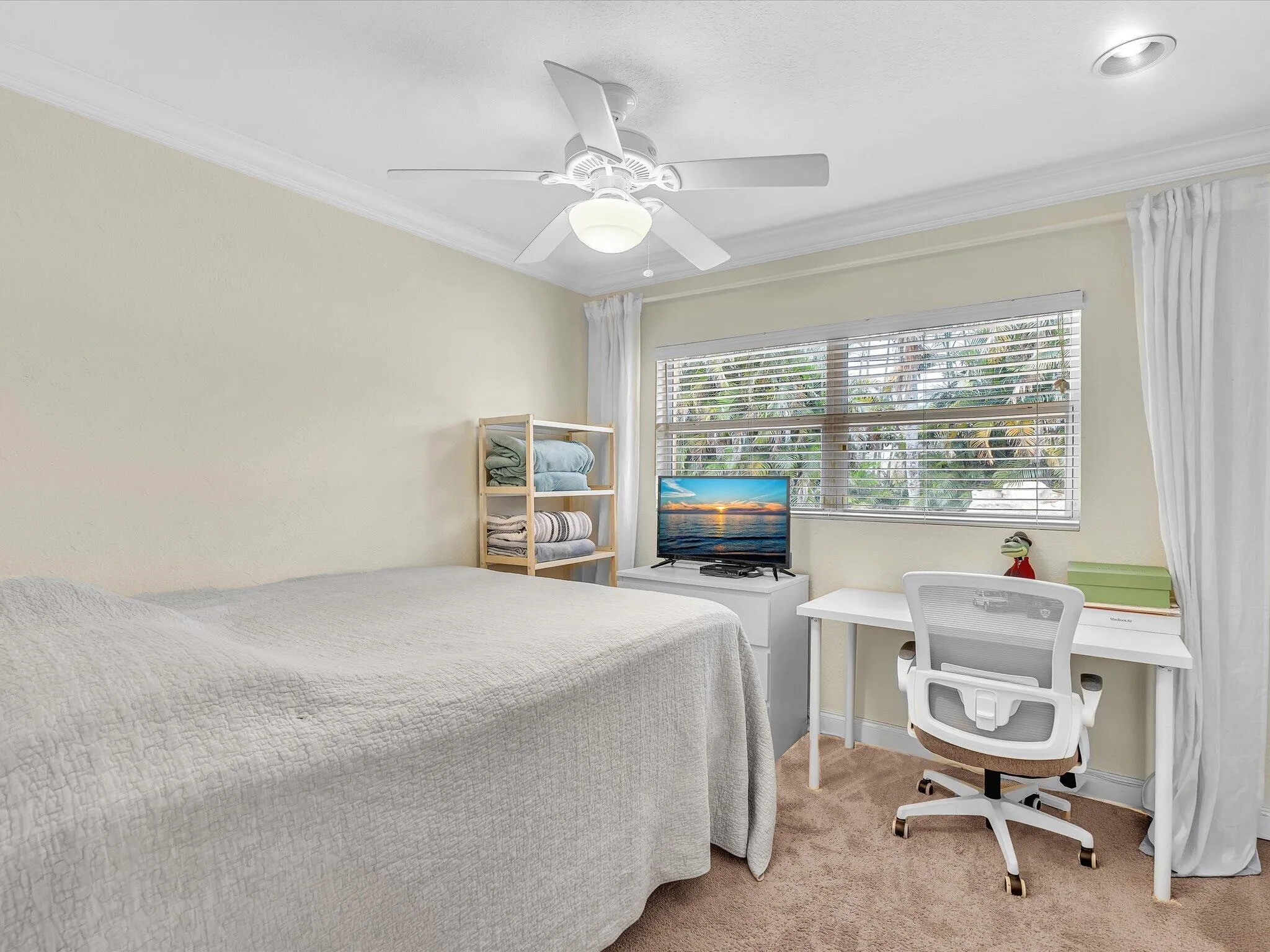 Recessed ceiling lighting, ceiling fan with integrated lighting, crown molding, double-pane window, and carpet flooring