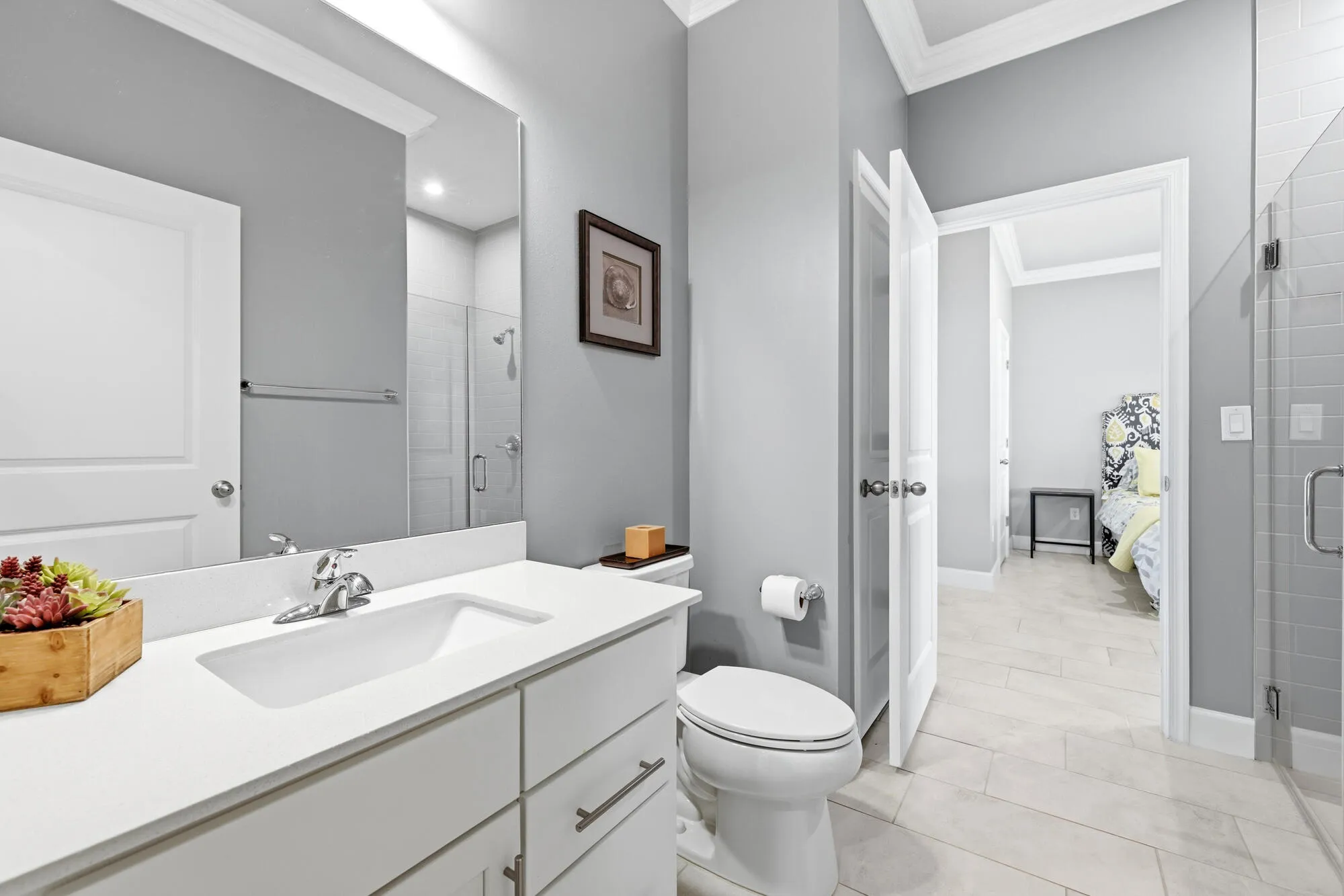 First floor full bathroom featuring a white vanity with an integrated sink, polished chrome faucet, and expansive wall mirror