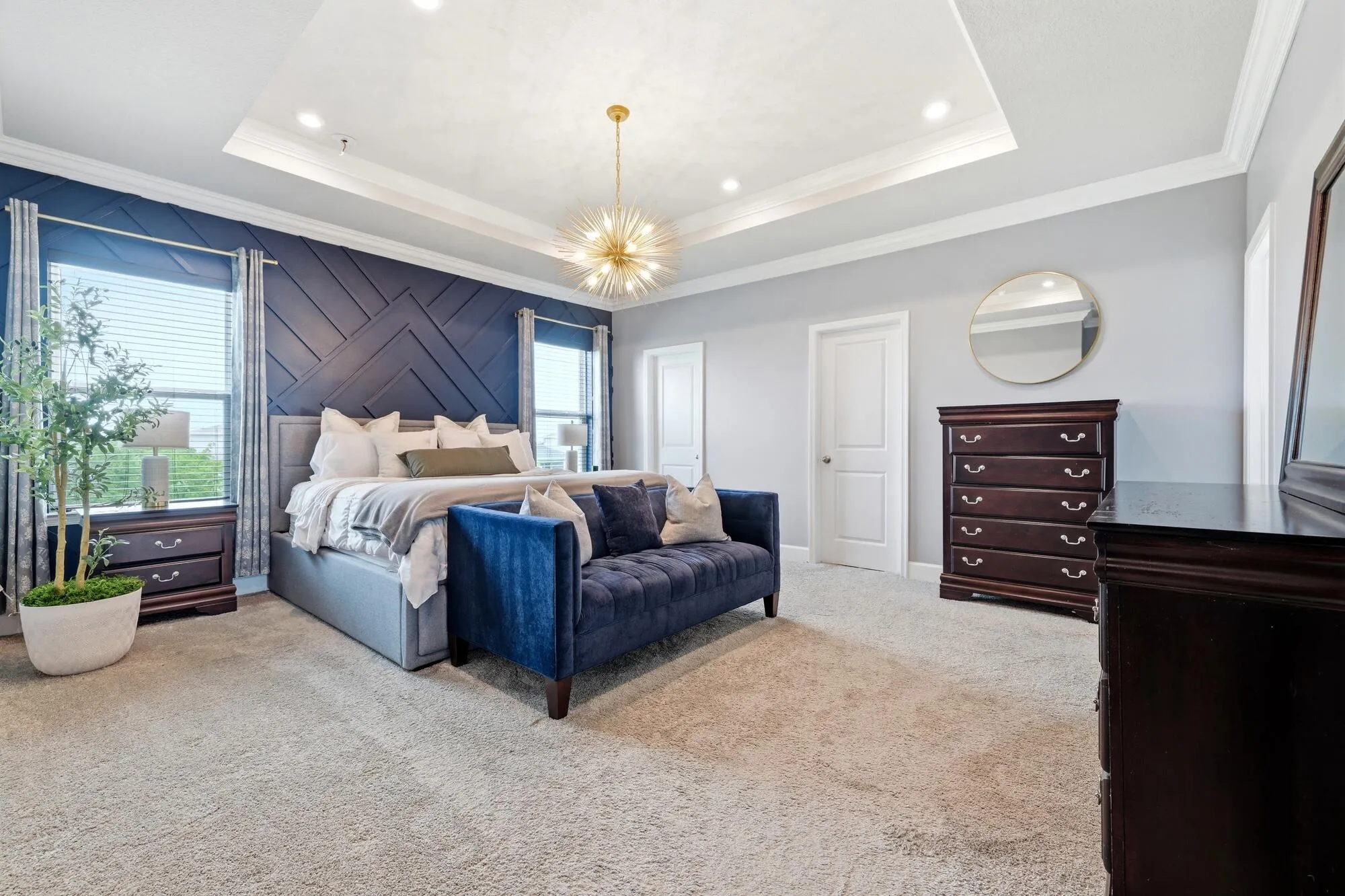 Primary suite, tray ceiling with recessed lighting and a contemporary central light fixture