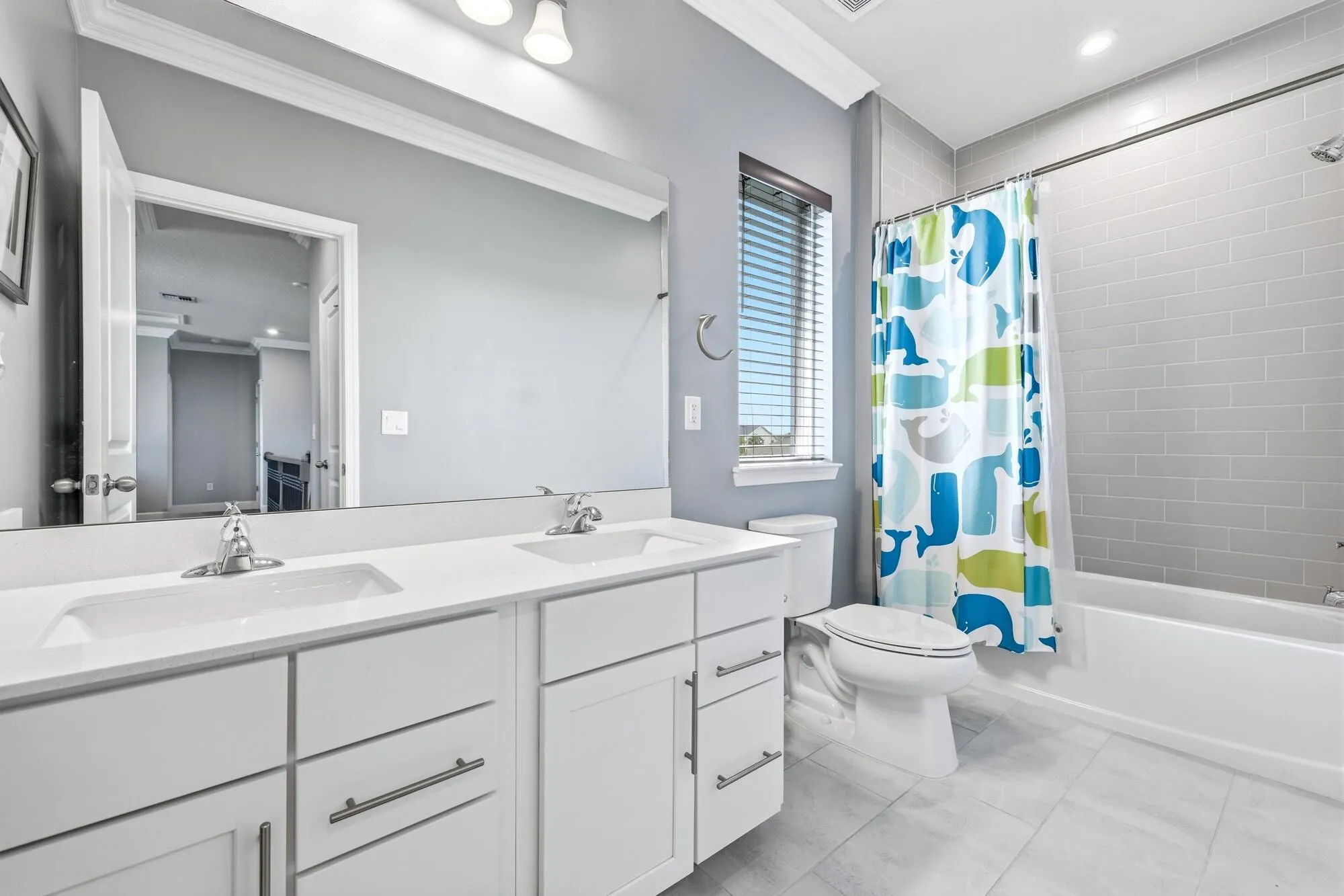 Bathroom in bedroom with dual sink vanity with white cabinetry and chrome fixtures