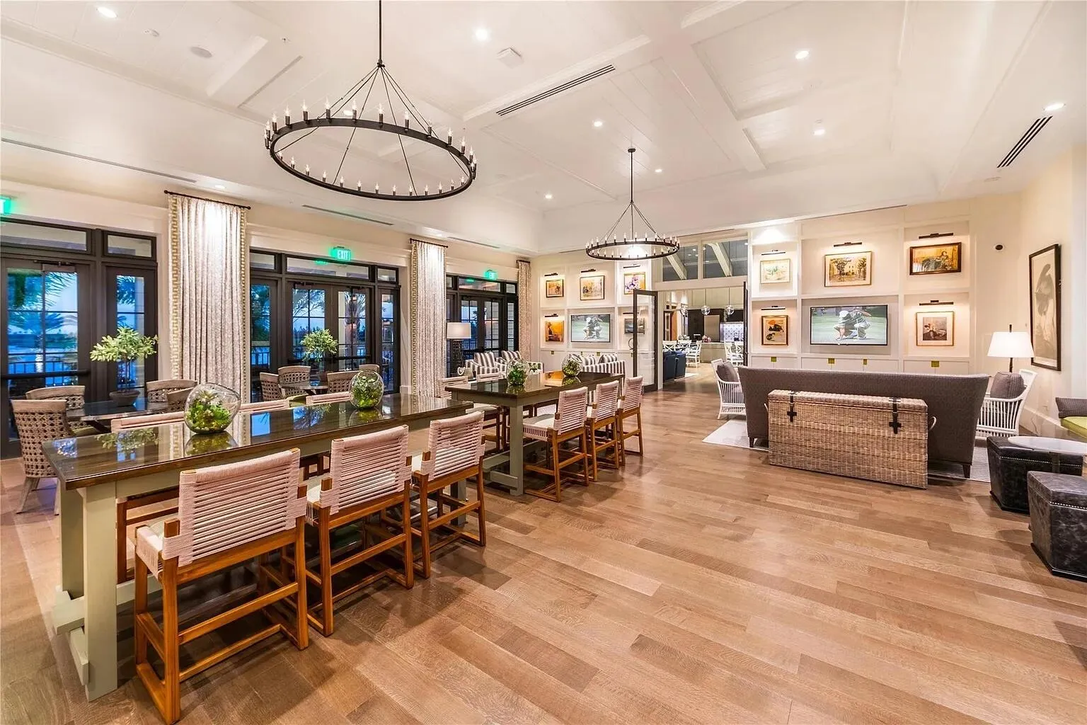 Clubhouse social lounge featuring cozy seating, communal dining tables, gallery wall art, and a media area — a welcoming space to relax or watch the game with neighbors.