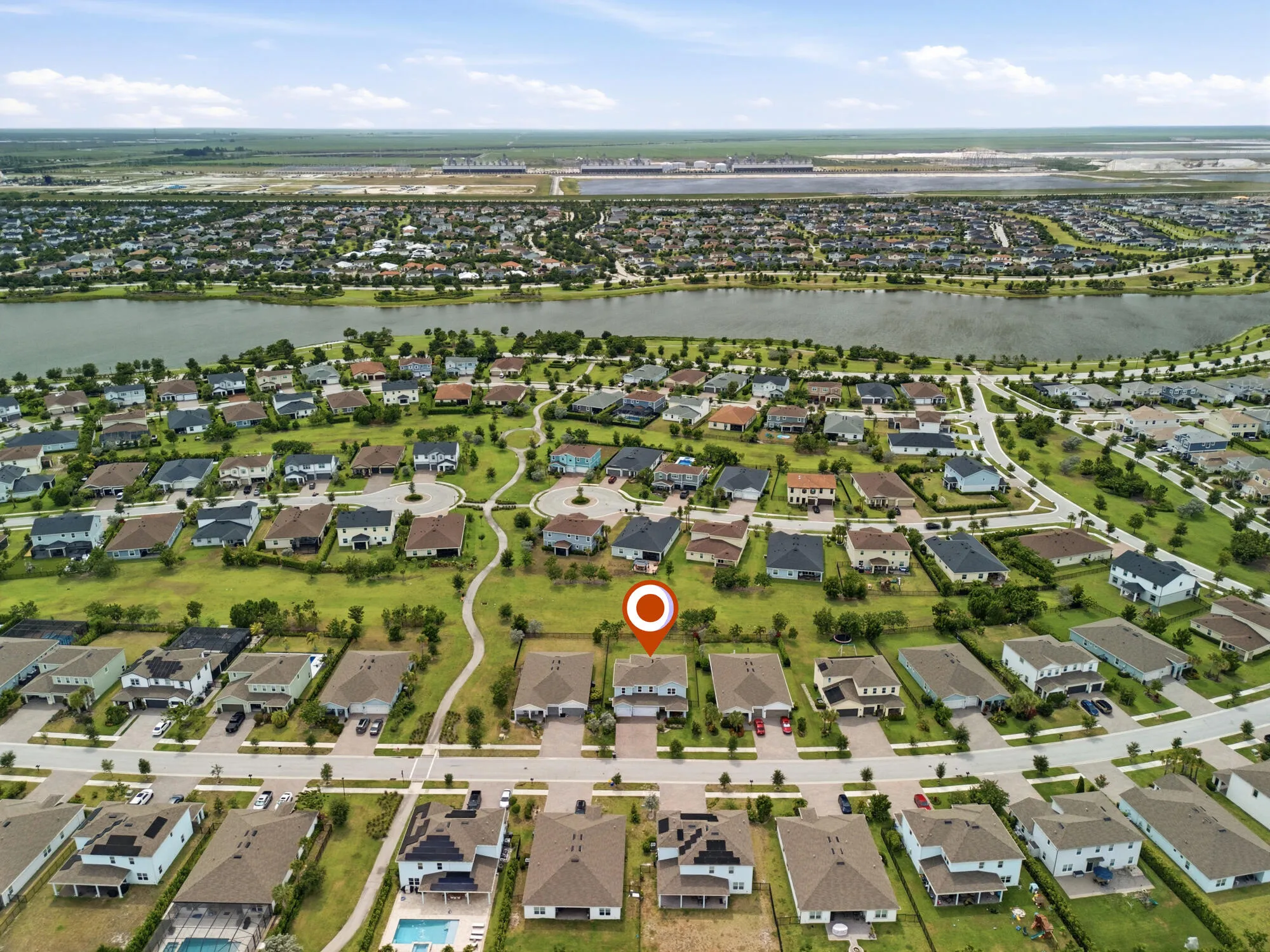 Aerial perspective showcasing a residential community with a central lake feature