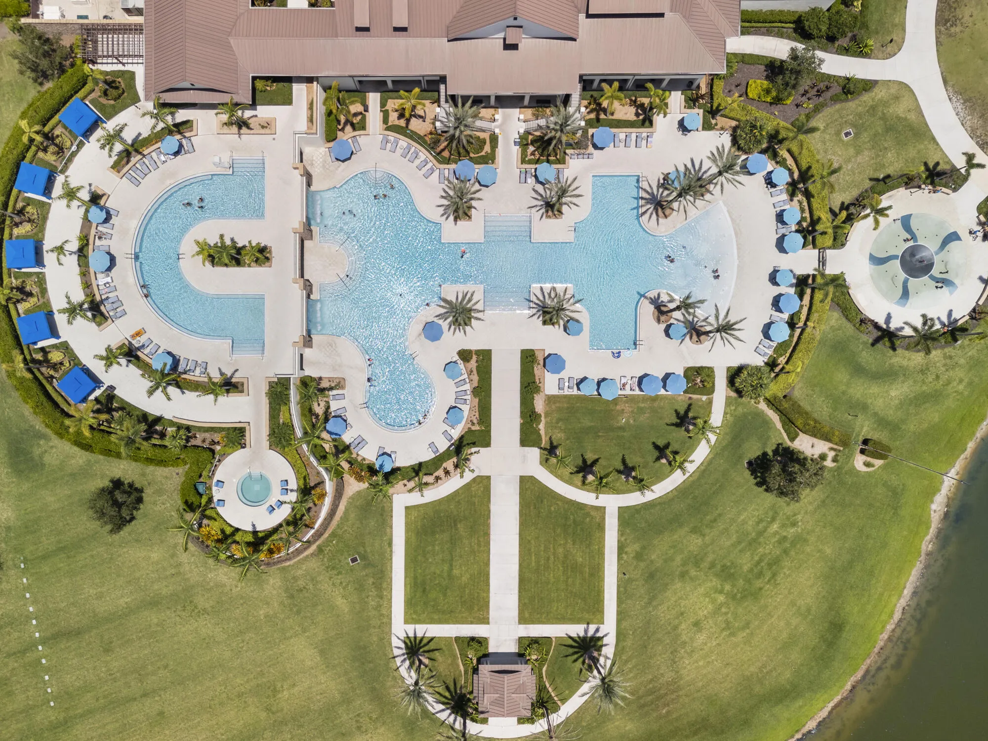 Expansive resort-style aquatic facility featuring multiple swimming pools, a splash pad, and a circular spa
