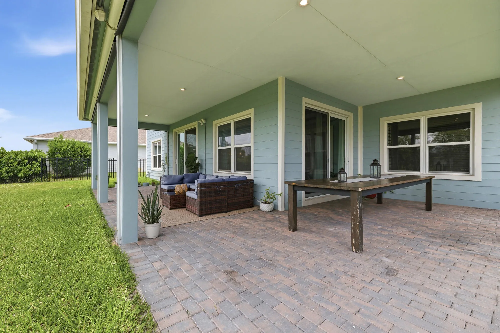 Expansive covered patio featuring brick paver flooring and recessed lighting