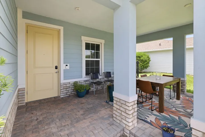 Covered porch featuring brick-finish columns and light blue siding