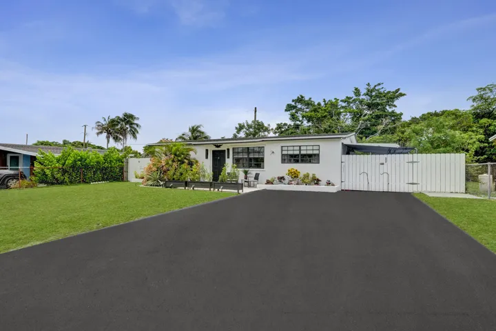 driveway -big enough for 4 cars, 1 in carport behind fence