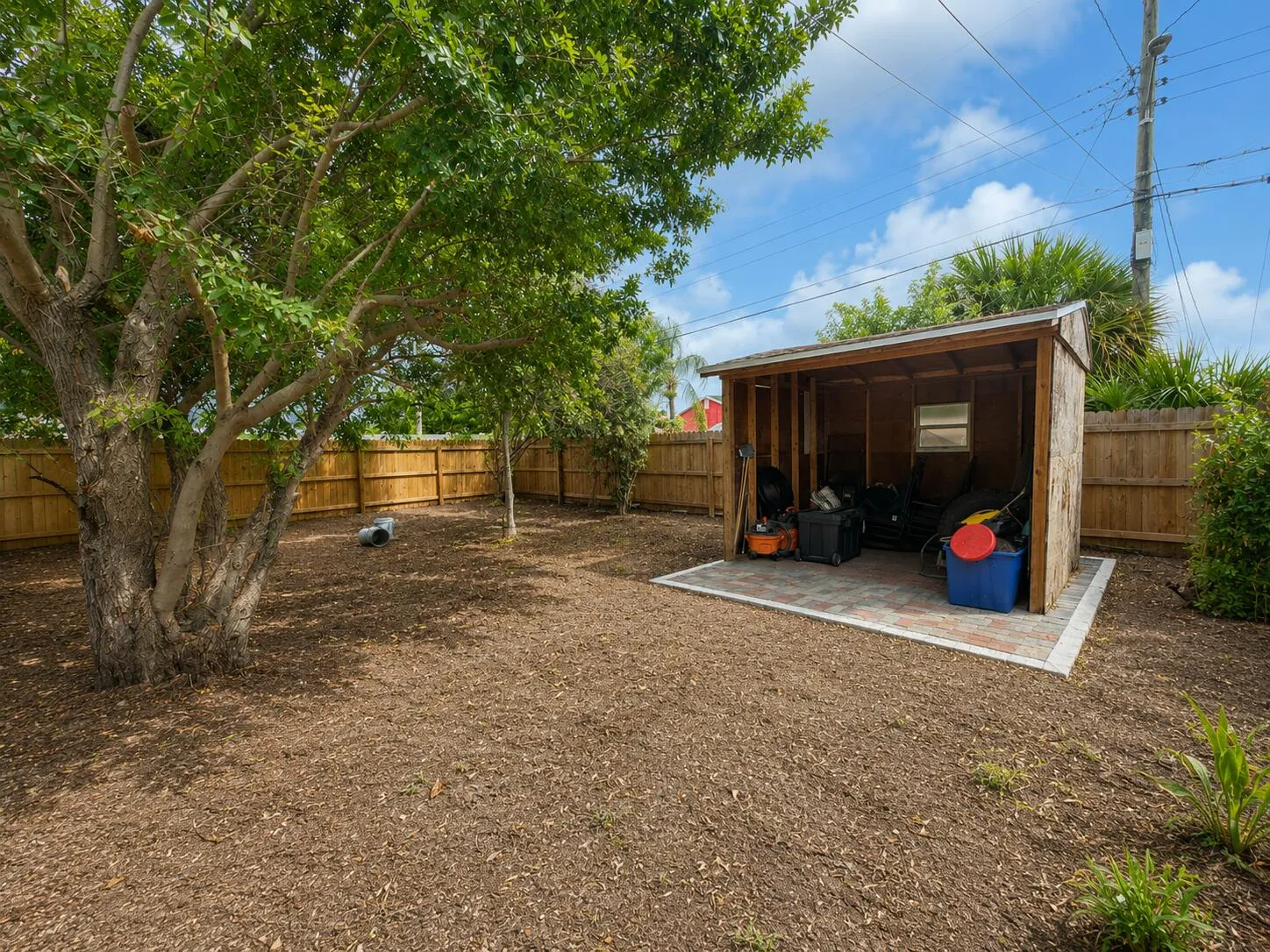 Convenient storage shed tucked into the fenced backyard — great for tools, lawn equipment, or extra storage, set on a paver base for easy access.
