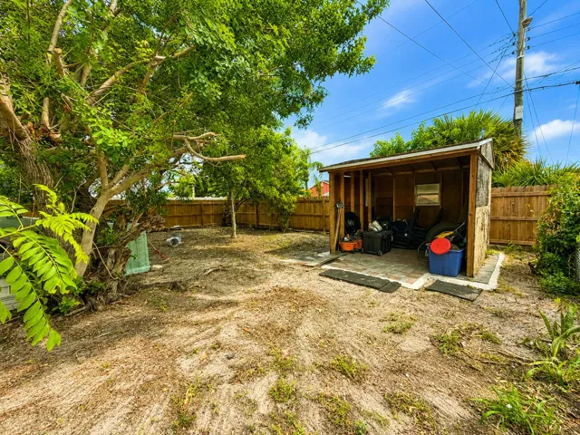 Storage shed with paver base tucked into a private, tree-lined corner of the yard