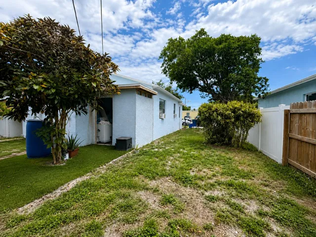 Side yard leading to a rear utility nook with washer hookup