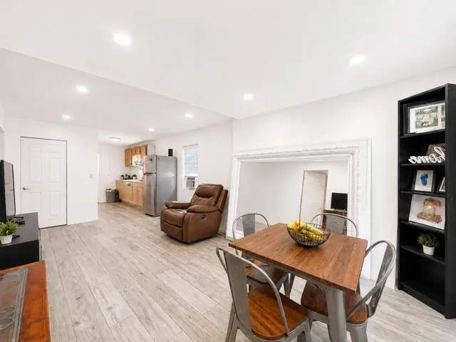 Open-concept living and dining space with wood-look flooring and recessed lighting throughout