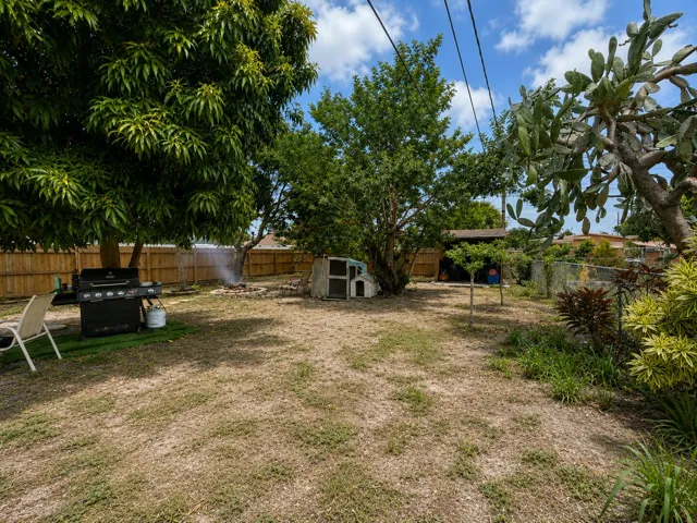 Spacious, fully fenced backyard offering plenty of room to relax or entertain. Mature shade trees, a cozy seating area, and a fire pit create a private outdoor retreat.