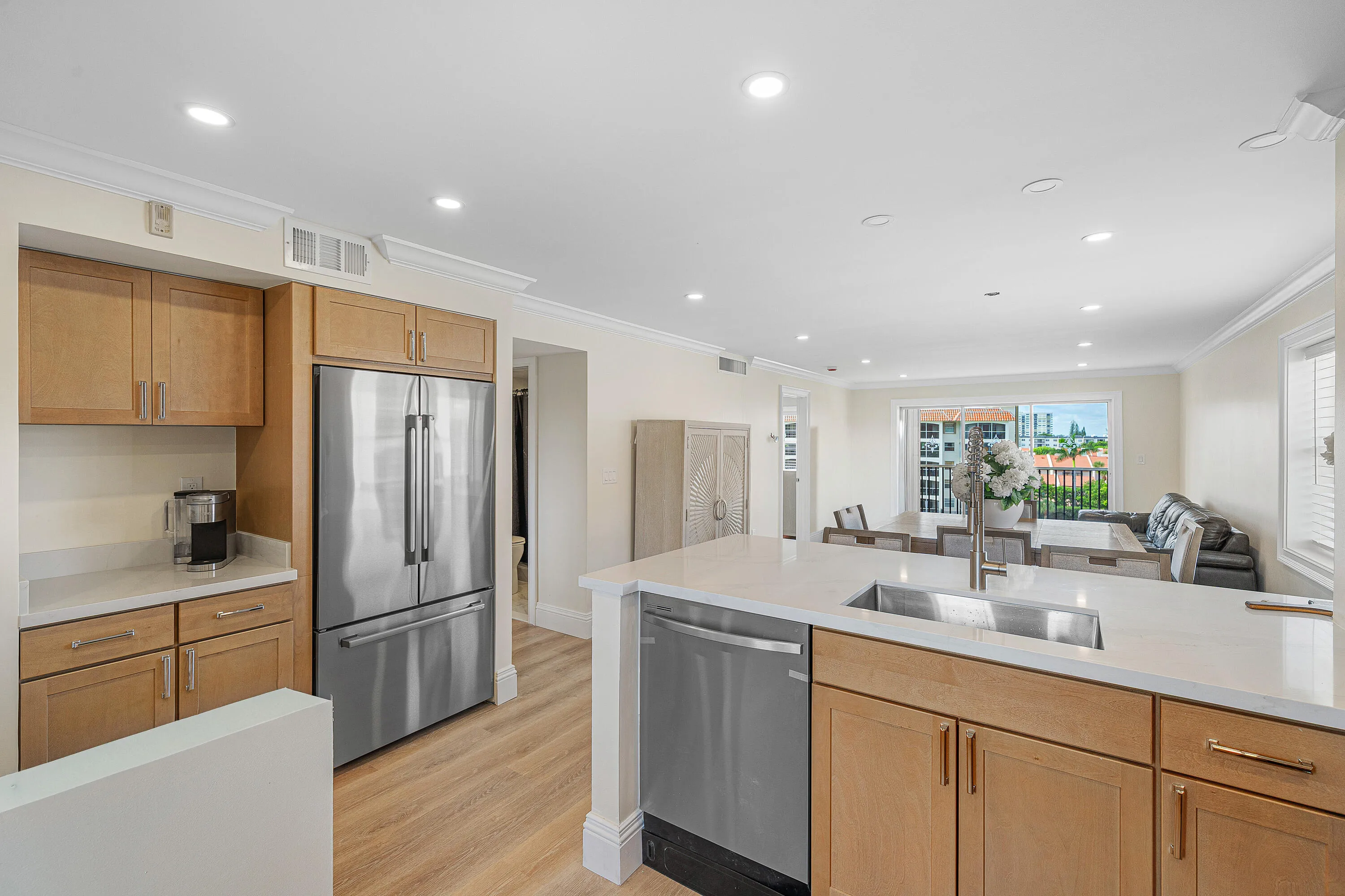 Open-concept kitchen featuring an island with an undermount sink and stainless steel dishwasher