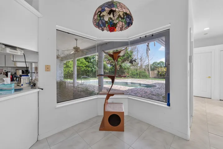 Bay window with full outdoor visibility, tile flooring, and a built-in kitchen pass-through