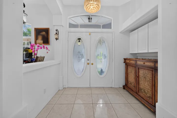 Double entry doors with oval glass inserts and transom window