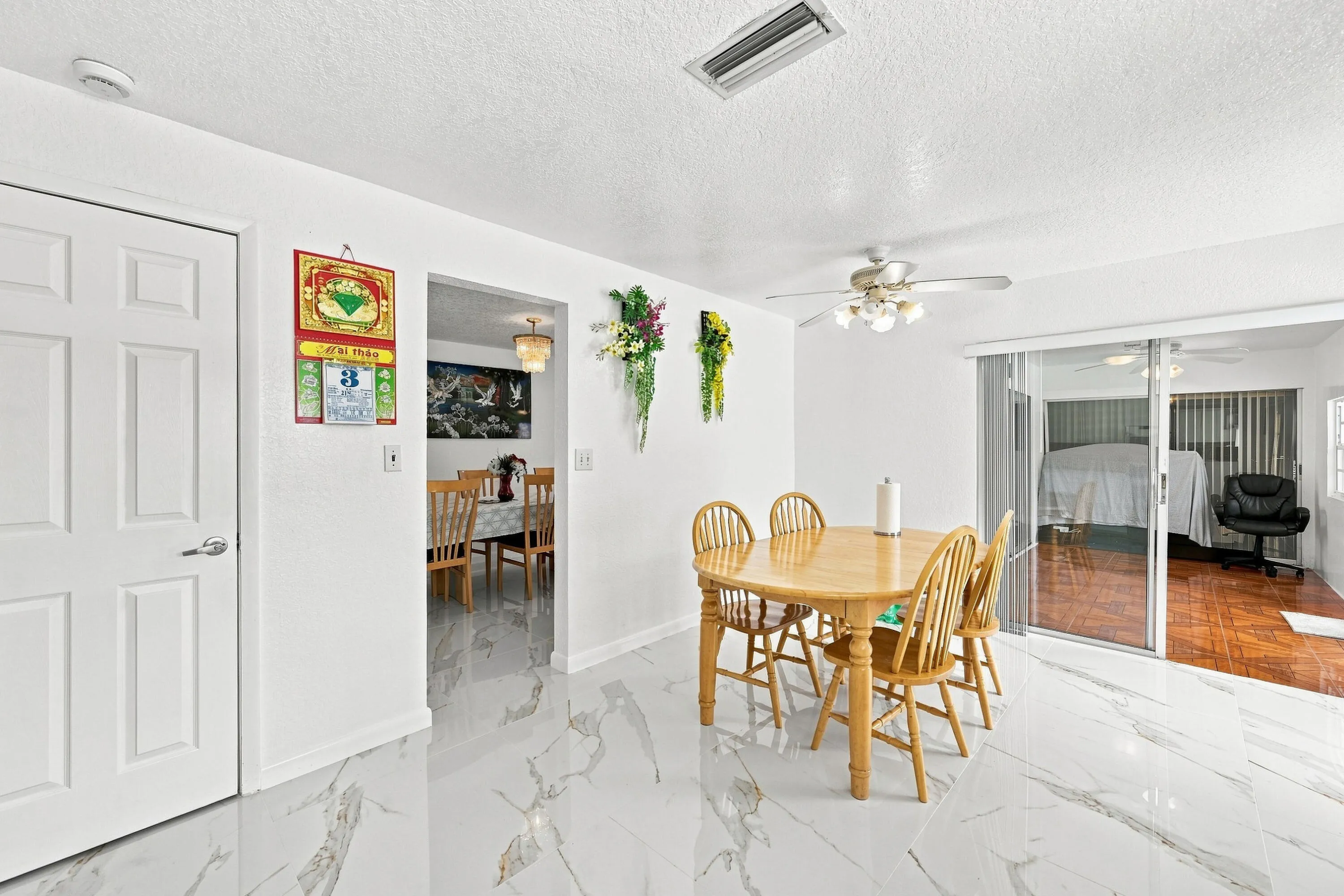 Bright interior room featuring white walls and white marble-look tile flooring